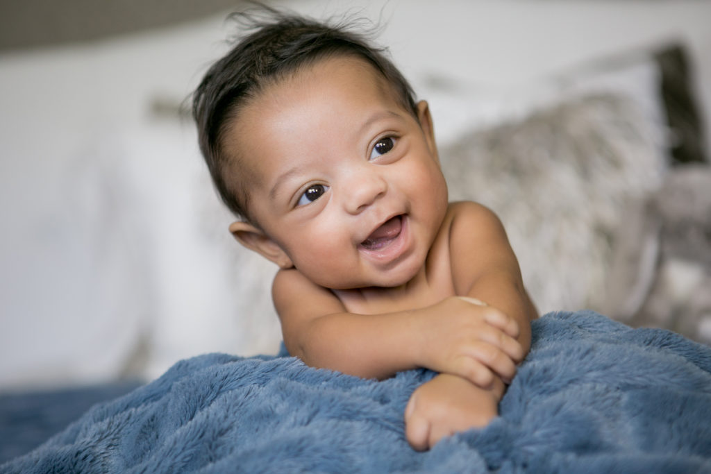 smiling baby tummy time racial premature boy